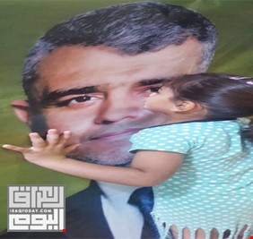 طفلة في مدينة الصدر تقبل صورة المرشح محمد صاحب الدراجي .. وهل هناك أصدق من الأطفال؟