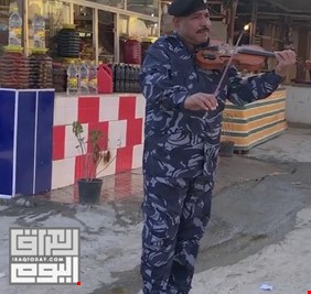 في صورة فريدة وباهرة.. شرطي عراقي يعزف على آلة الكمان في أحد اسواق الحلة، وينال التصفيق