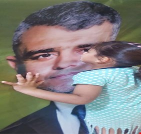 طفلة في مدينة الصدر تقبل صورة المرشح محمد صاحب الدراجي .. وهل هناك أصدق من الأطفال؟