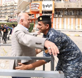 بالصورة.. شرطي يفتش رئيس الحكومة حيدر العبادي قبل دخوله للمركز الإنتخابي..