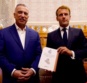 ماكرون يحمل كتابا عليه صورة  السيد السيستاني.. تعرف على قصته