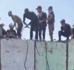 المتظاهرون يباشرون بربط الاسلاك على الحواجز الكونكريتية لاسقاطها ودخول الخضراء