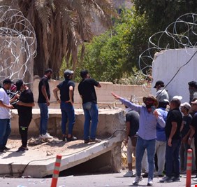 متظاهرون من التيار الصدري يسقطون عددا من الكتل الكونكريتية على أسوار الخضراء